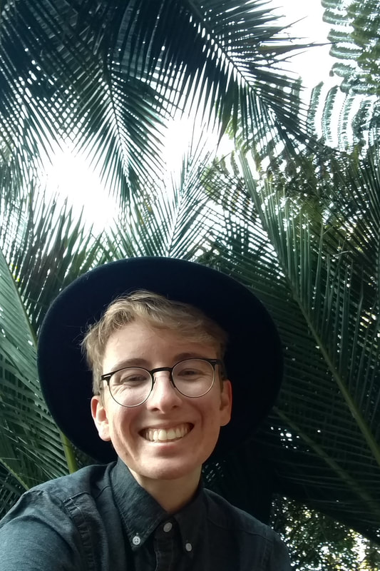 A Picture of a person in front of palm trees
